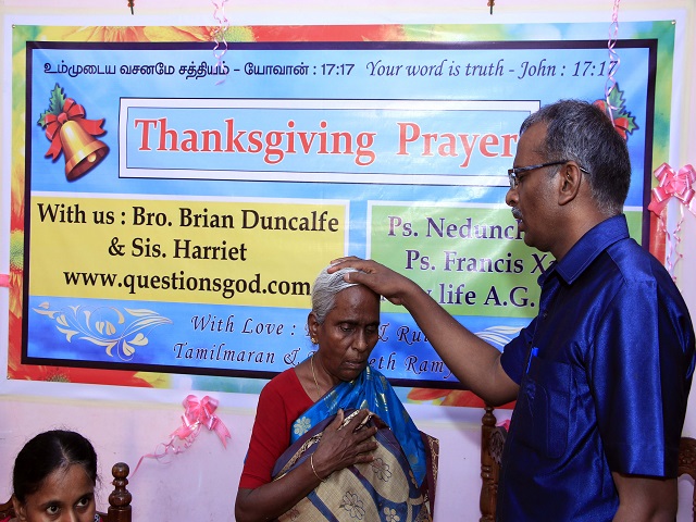 Tamil praying for a lady at his Church