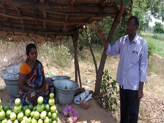 Tamil sharing the gospel with a fruit vendor.