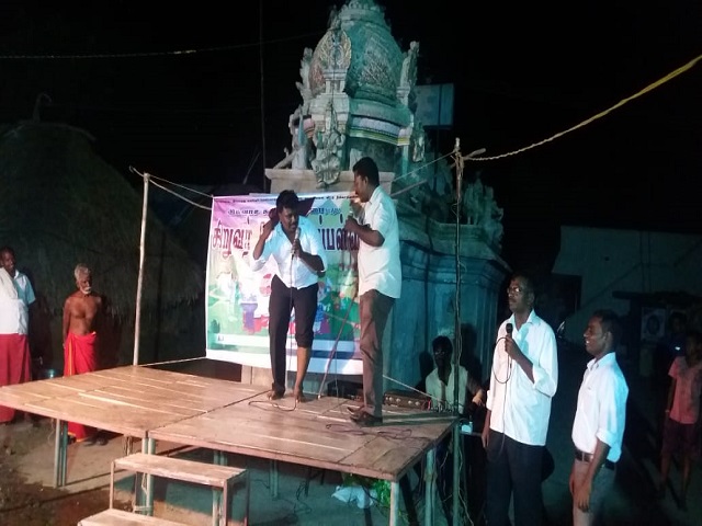 Tamil and his Pastor  preaching in a village in India.